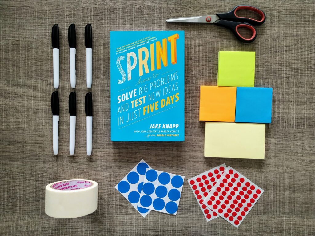 Boken Sprint tillsammans med material som oftast används under en design sprint.